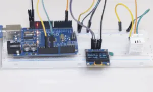 Projekt am2302: Arduino Uno z czujnikiem temperatury i wilgotności DHT22, wyświetlaczem OLED i płytką stykową.
