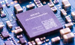 Zbliżenie na płytkę drukowaną z widocznym układem MEMS accelerometer, kluczowym elementem w telefonie do pomiaru ruchu.
