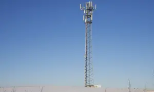 Wieża telekomunikacyjna na tle błękitnego nieba. Wokół śnieg. To może być część infrastruktury TDD, co to jest?