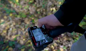 Ręka trzymająca cyfrowy wyświetlacz wykrywacza metali. To urządzenie, czyli magnetometr, pomaga znaleźć ukryte przedmioty.