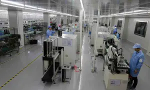 Pracownicy w czystym pomieszczeniu nadzorują proces drukowania płytek PCB na nowoczesnych liniach produkcyjnych.