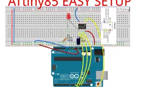 Układ ATtiny85 na płytce stykowej, podłączony do Arduino Uno. Widoczny rezystor, kondensator i dioda LED.