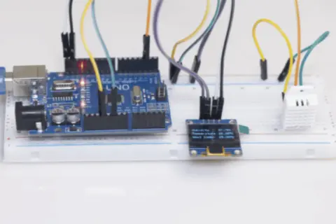 Projekt am2302: Arduino Uno z czujnikiem temperatury i wilgotności DHT22, wyświetlaczem OLED i płytką stykową.