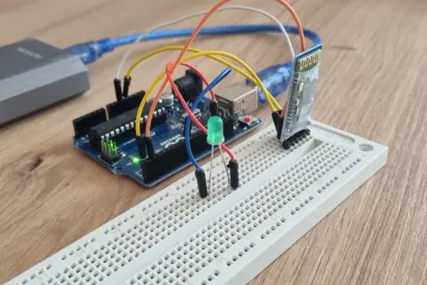 Arduino z modułem **arduino bluetooth hc-05** i zieloną diodą LED na płytce stykowej.