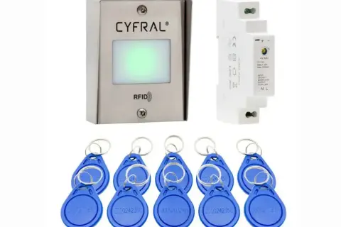 Zestaw kontroli dostępu: czytnik **transponderów RFID** Cyfral, zasilacz i 8 niebieskich breloków.