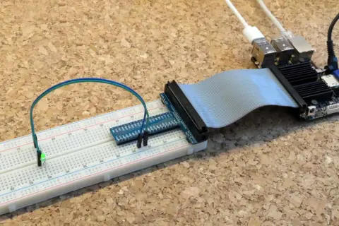 Odroid C2 z podłączoną taśmą do płytki stykowej, na której świeci zielona dioda LED.