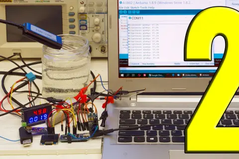 Pomiar napięcia Arduino z użyciem sondy w wodzie. Na ekranie komputera widać kod i wyniki pomiarów wilgotności gleby.