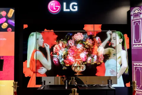 LG transparent OLED z bukietem kwiatów i kobietami. Technologia pozwala na niemal niewidoczny ekran.