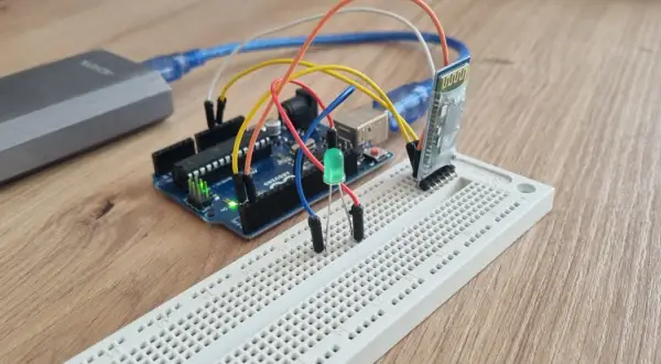 Arduino z modułem **arduino bluetooth hc-05** i zieloną diodą LED na płytce stykowej.