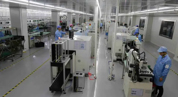 Pracownicy w czystym pomieszczeniu nadzorują proces drukowania płytek PCB na nowoczesnych liniach produkcyjnych.