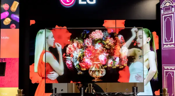 LG transparent OLED z bukietem kwiatów i kobietami. Technologia pozwala na niemal niewidoczny ekran.