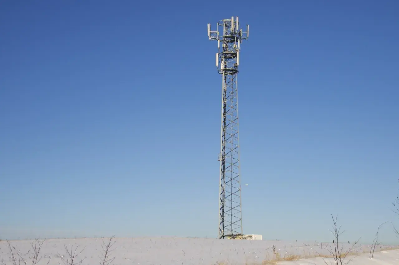 Wieża telekomunikacyjna na tle błękitnego nieba. Wokół śnieg. To może być część infrastruktury TDD, co to jest?