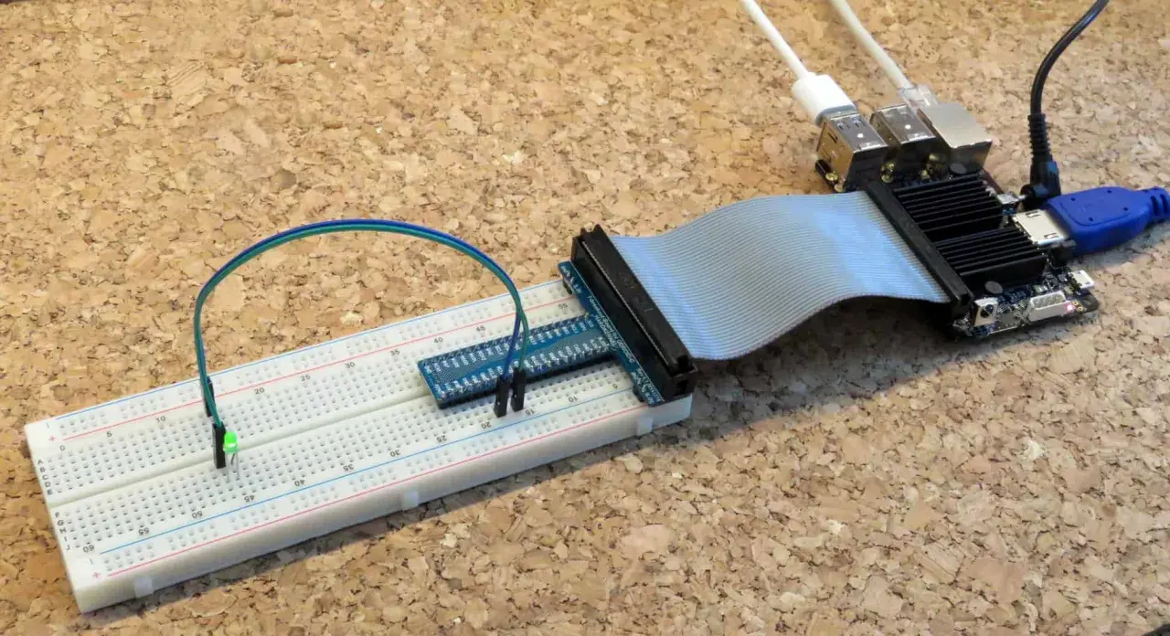 Odroid C2 z podłączoną taśmą do płytki stykowej, na której świeci zielona dioda LED.