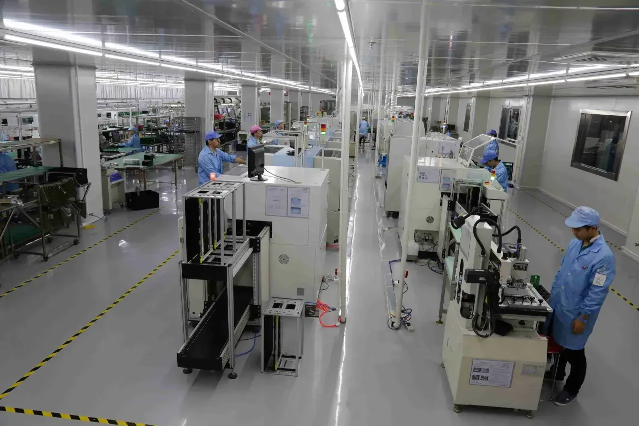 Pracownicy w czystym pomieszczeniu nadzorują proces drukowania płytek PCB na nowoczesnych liniach produkcyjnych.