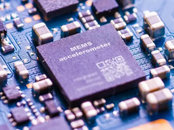 Zbliżenie na płytkę drukowaną z widocznym układem MEMS accelerometer, kluczowym elementem w telefonie do pomiaru ruchu.