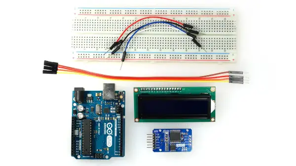Zestaw do budowy zegara Arduino: płytka stykowa, moduł wyświetlacza LCD, moduł zegara DS3231 i przewody połączeniowe.