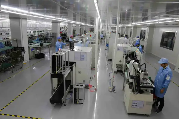 Pracownicy w czystym pomieszczeniu nadzorują proces drukowania płytek PCB na nowoczesnych liniach produkcyjnych.