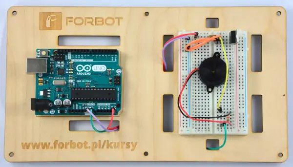 Arduino Uno z podłączonym buzzerem na płytce stykowej, gotowe do eksperymentów.